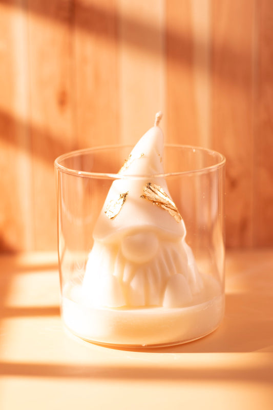 Handcrafted white Christmas gnome candle with gold accents in a glass jar