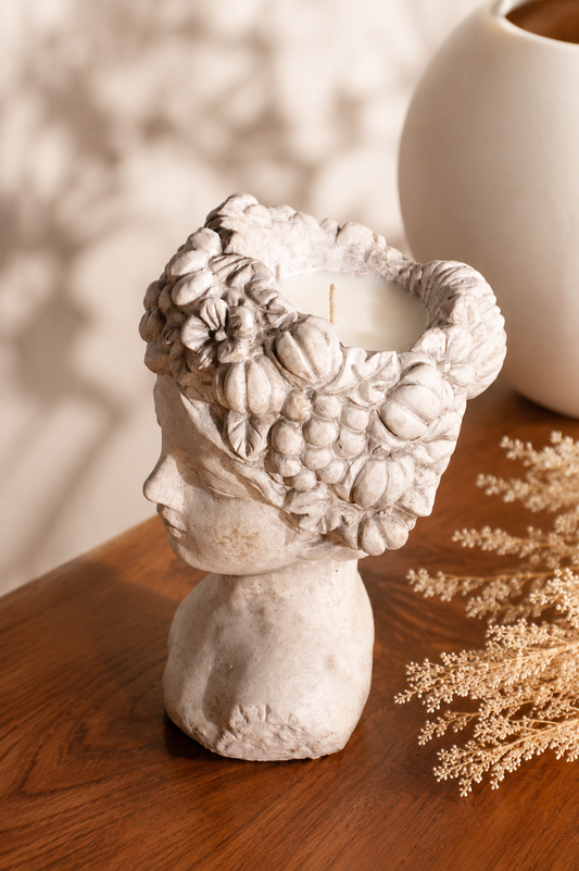 Stone-look bust vessel with fruit-and-flower crown and white wax pool on top