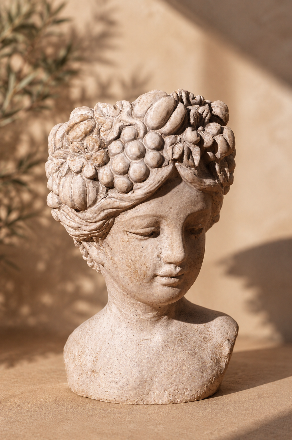 Close portrait of bust candle vessel with grape and fruit crown
