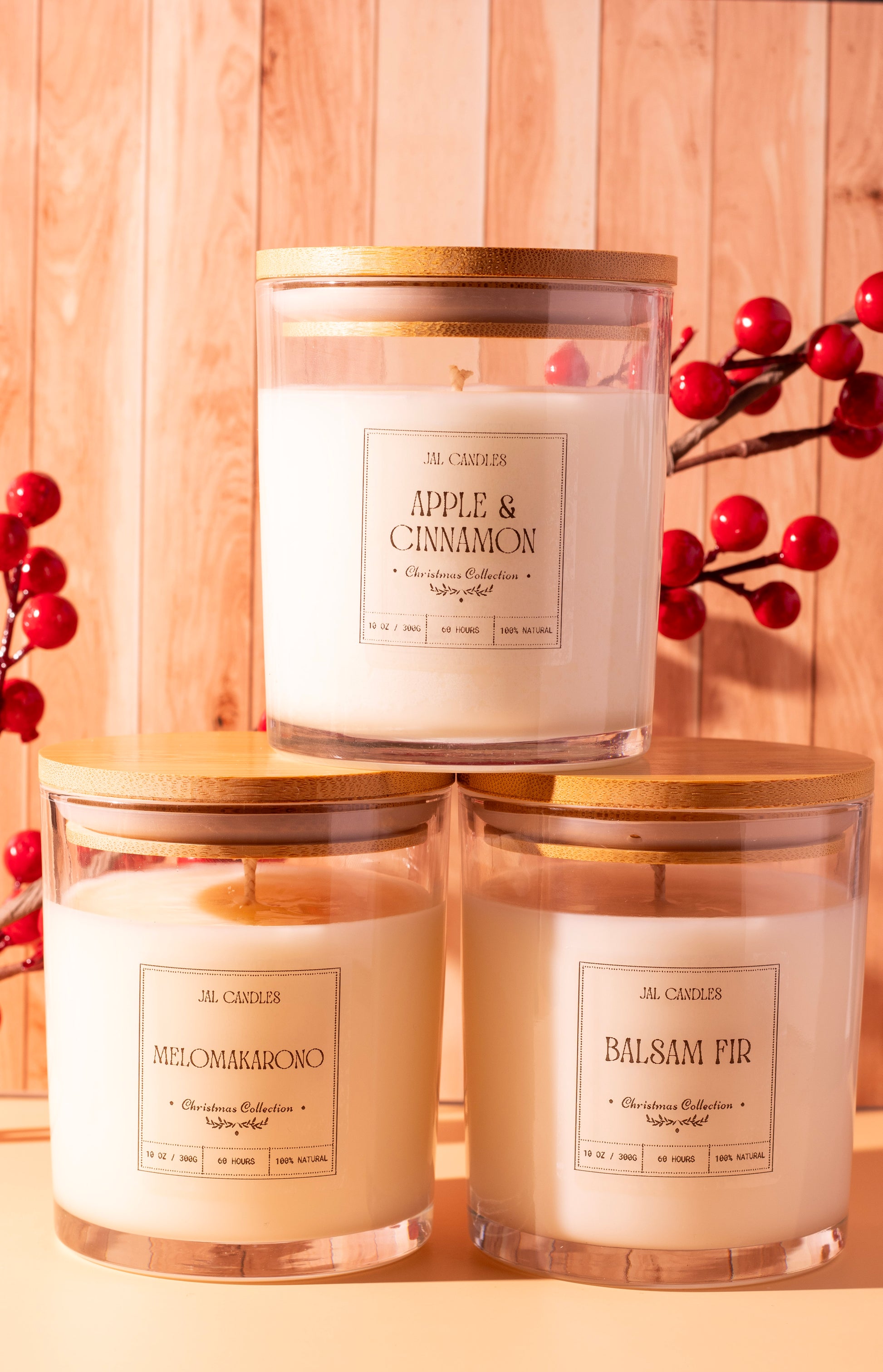 JAL Candles Christmas candle trio gift set featuring Balsam Fir, Apple & Cinnamon, and Melomakarono scents, hand-poured in Cyprus from coconut-soy wax with wooden lids and festive red berries.