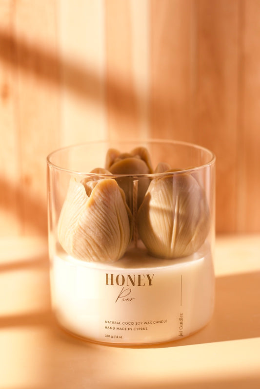 Clear jar candle topped with three green-taupe wax tulips and three wicks