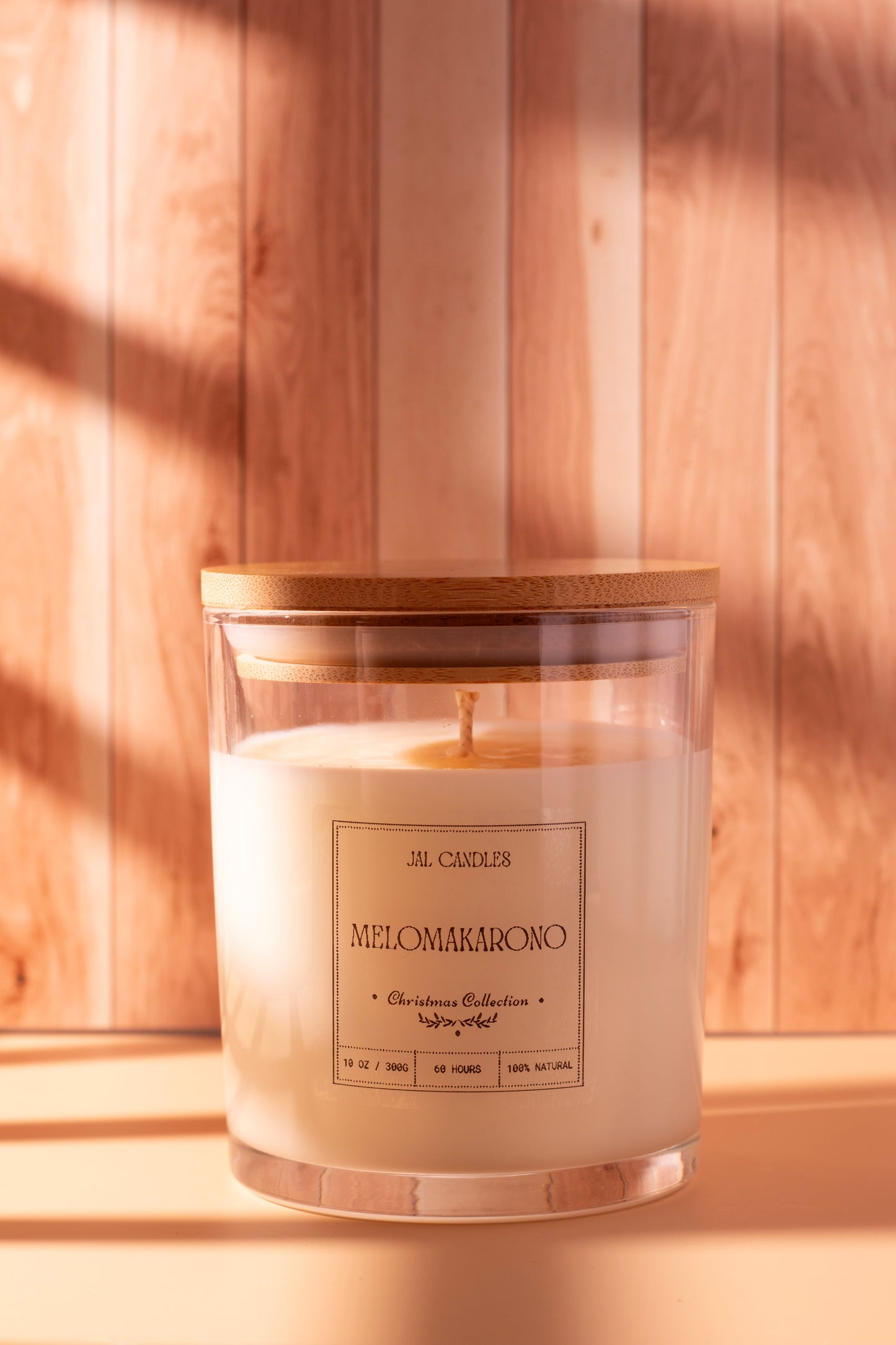 Handcrafted Melomakarono Christmas candle by JAL Candles, inspired by the traditional Greek holiday dessert, made from coconut-soy wax and photographed in cozy festive light in Cyprus.