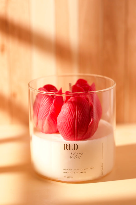 Clear jar candle topped with three red wax tulips and a wooden wick