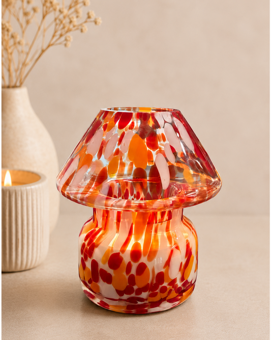 Speckled red-orange mushroom glass candle lamp glowing warmly
